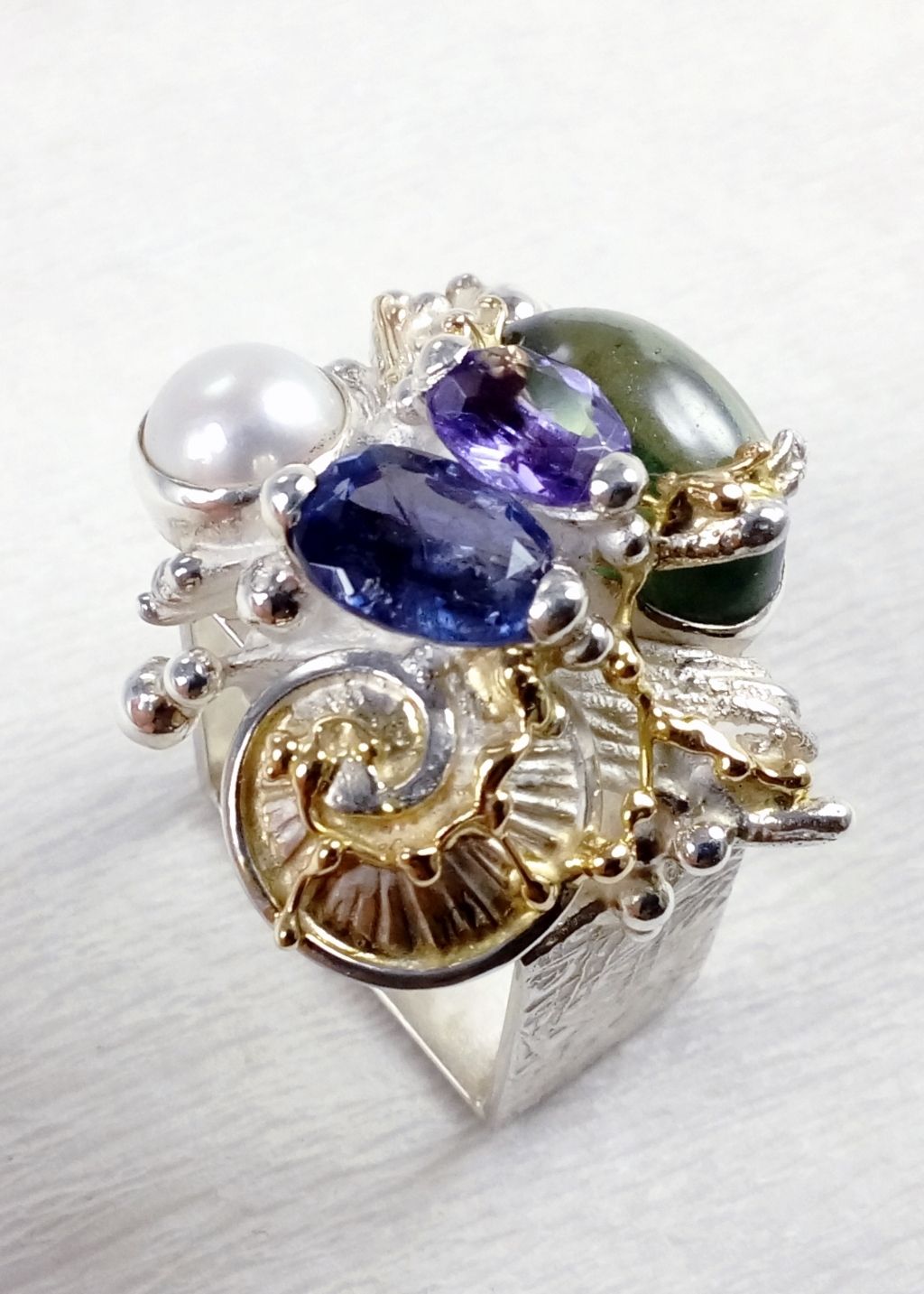 jewelry made from gold and silver, jewelry with color stones, jewelry with real pearls, gregory pyra piro square ring 4821, where to find an auction house with gemstones and jewellery, fine craft gallery handcrafted ring for sale, sterling silver and 14 karat gold ring, ring with amethyst, fluorite, iolite and pearl, one of a kind handcrafted ring, where to find auctions with fine art and designer jewellery, where to buy gregory pyra piro jewelry right now