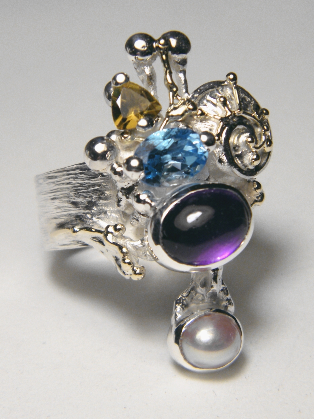 mixed metal jewelry made from silver and gold, gregory pyra piro handcrafted riing 4020, handcrafted rings for women with amethyst and blue topaz, handcrafted rings for women with blue topaz and peridot, handcrafted rings for women with amethyst and blue topaz, handcrafted jewellery with facet cut gemstones and pearls, handcrafted jewellery and rings shown in art and craft galleries