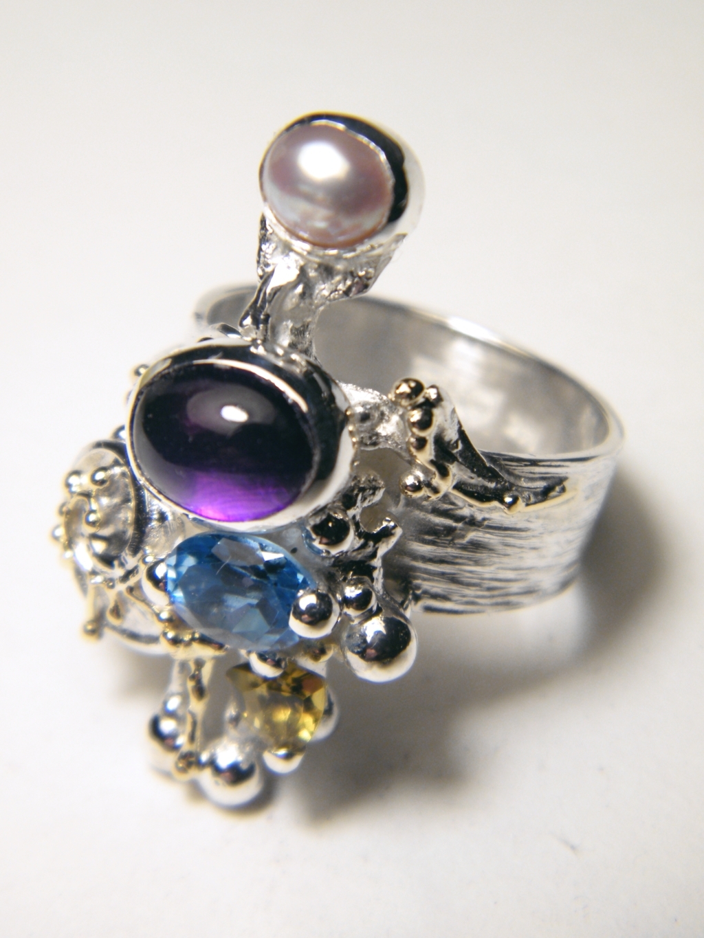 mixed metal jewelry made from silver and gold, gregory pyra piro handcrafted riing 4020, handcrafted rings for women with amethyst and blue topaz, handcrafted rings for women with blue topaz and peridot, handcrafted rings for women with amethyst and blue topaz, handcrafted jewellery with facet cut gemstones and pearls, handcrafted jewellery and rings shown in art and craft galleries