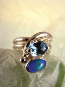 Silber und Gold Ring mit blauer Topas und Opal, einzigartiger Designschmuck mit blauer Topas und Opal, Kunstschmuck mit blauer Topas und Opal, Silber und Gold Schmukkunst mit blauer Topas und Opal, Silber und Gold Einzelstück Schmuck mit blauer Topas und Opal, Gregory Pyra Piro handgefertigter Ring 2015, Gregory Pyra Piro Ring mit einstellbarer Größe, einzigartiger Designring aus Gold und Silber, einzigartiger Designgoldschmied mit gemischten Metallen, einzigartiger Designring mit blauem Topas und Opal, einzigartiger Designschmuck, der in Kunstgalerien gezeigt wird