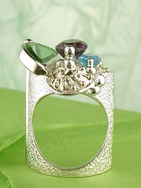 Gregory Pyra Piro handgjord hantverks ring 7563, ring av guld och silver, ring med ametist och blå topas, ring med facetterade ädelstenar och grönt glas, smycken visas på internationella mässor, smycken som säljs i konstgallerier