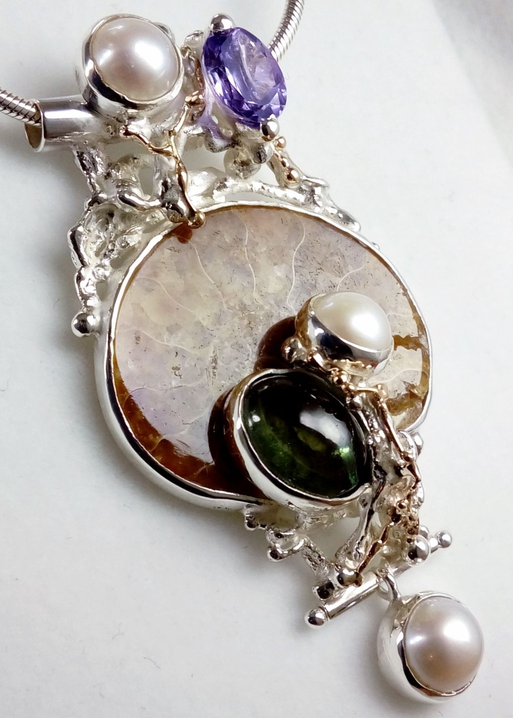 gregory pyra piro hanger 4921, art nouveau geïnspireerde mode-sieraden, handgemaakte sieraden voor vrouwen met antiek motief, waar art nouveau geïnspireerde mode-sieraden te vinden zijn, fijne sieraden geïnspireerd door retro mode, sieraden en antiekwinkels, winkel voor antiek en sieraden, winkel voor vintage sieraden, zijn er nog kunstenaars en ontwerpers die op de ouderwetse manier sieraden maken, waar eigentijdse sieraden te vinden zijn met een antiek motief, hanger met een vintage geïnspireerd design, sterling zilver en 14 karaat gouden hanger, hanger met facetgeslepen amethist en fluoriet, hanger met amethist en ammoniet, hanger met ammoniet en fluoriet, unieke handgemaakte ring, sieraden zoals bij hedendaags handwerk en design, hedendaagse sieraden geïnspireerd door art edwardian en victoriaanse tijdperk, hedendaagse sieraden geïnspireerd door Victoriaanse en edwardiaanse mode, antieke en vintage stijl geïnspireerde sieraden, waar makers te vinden die retro maken mode en art nouveau geïnspireerde sieraden