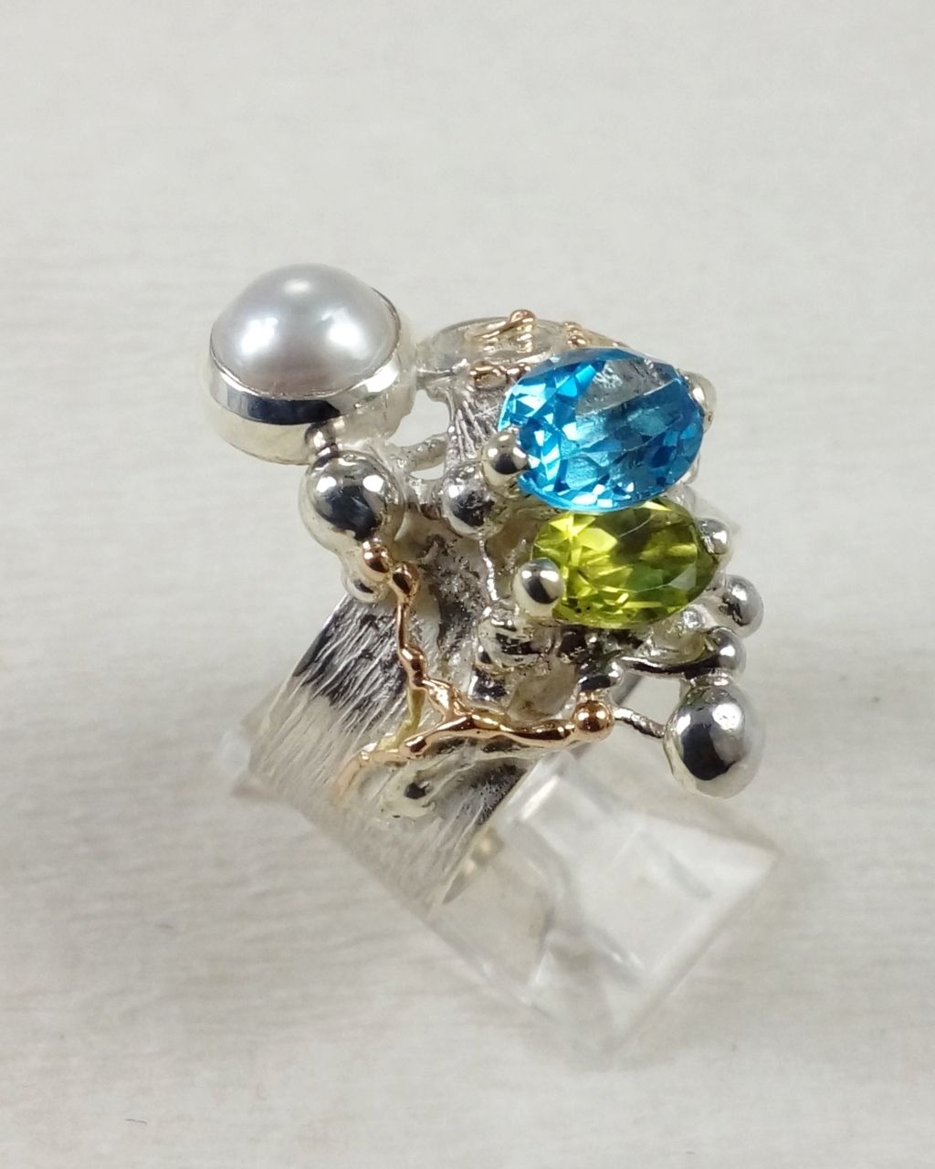 Gregory Pyra Piro prsten 3025, prsten s modrým topásem a peridotem, prsten s fazetovanými drahokamy a perlami, prsten ručně vyráběný řemeslníkem, prsteny prodávané v galeriích, šperky s doručením do Brna, šperky s doručením do Ostravy, šperky s doručením v Čechách